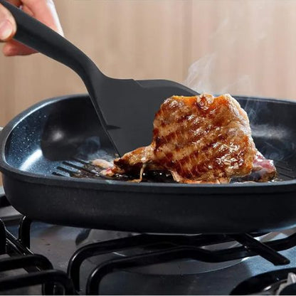 Spatule qui tourne un morceau de viande.