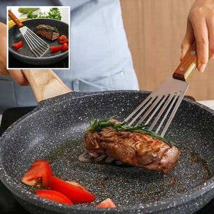 La spatule en acier qui retourne un morceau de viande.
